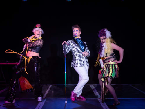 Three drag kings stood on stage at Theatre Deli