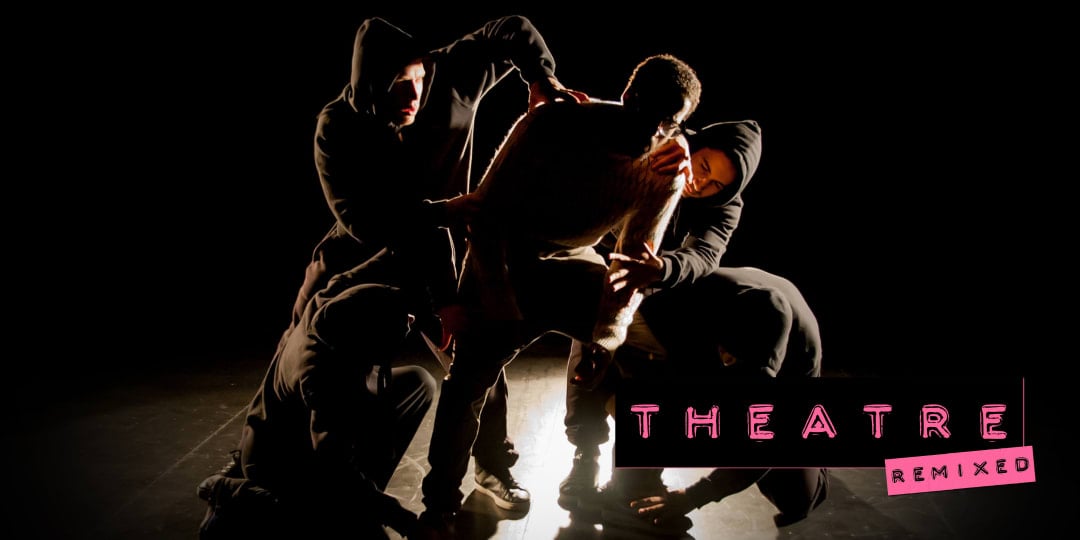 A group wearing hoodies pose in dance moves around a man in the centre of a stage.